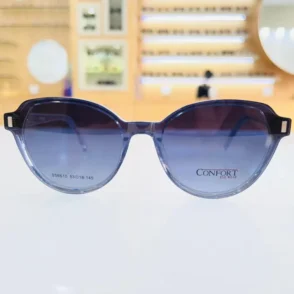 Gros plan sur des lunettes bleu avec touches noires, monture arrondie brillante, coins accentués et branches fines.