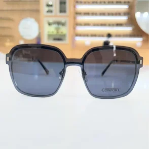 Gros plan sur des lunettes carrées noires brillantes, branches minces et plaquettes nasales visibles pour un rendu tendance.