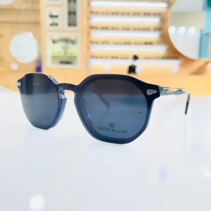 Gros plan de lunettes clips homme noires, branches fines translucides et détails métalliques sur la monture brillante.