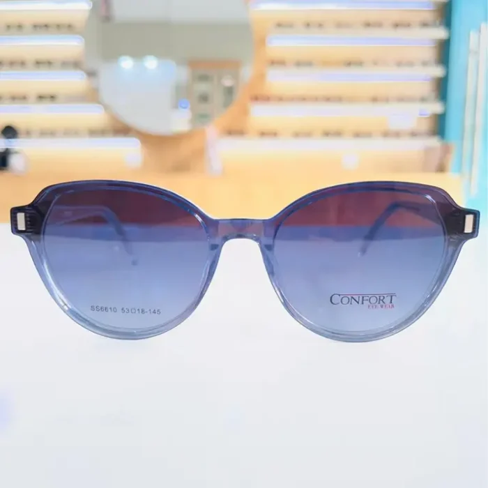 Gros plan de lunettes œil de chat bleues avec verres noirs dégradés et détails rectangulaires aux coins, finition brillante.