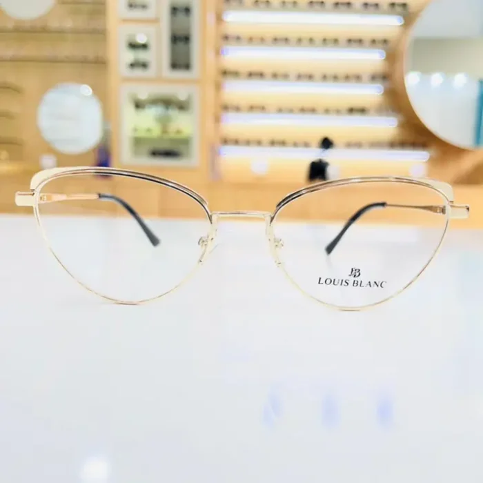 Gros plan sur lunettes œil de chat dorées en métal brillant, monture fine et branches délicates tendance.