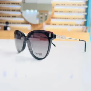 Gros plan sur lunettes œil de chat noires épaisses, avec branches métal argenté et détails décoratifs.