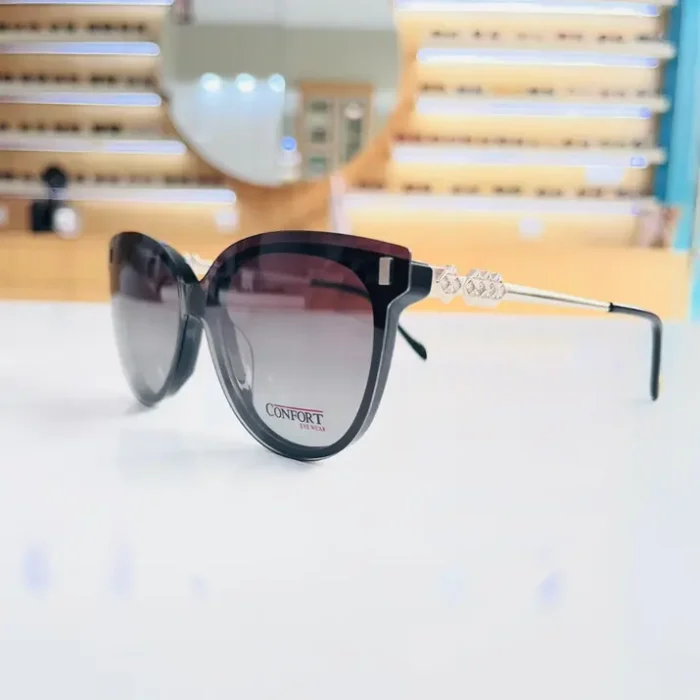 Gros plan sur lunettes œil de chat noires épaisses, avec branches métal argenté et détails décoratifs.