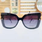 Gros plan sur des lunettes œil de chat noires brillantes, avec touches transparentes et éléments dorés visibles sur la branche.