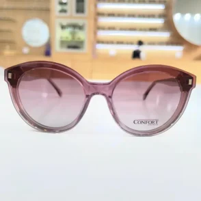Gros plan sur lunettes œil de chat rose transparent, branches fines et décor carré aux coins supérieurs.