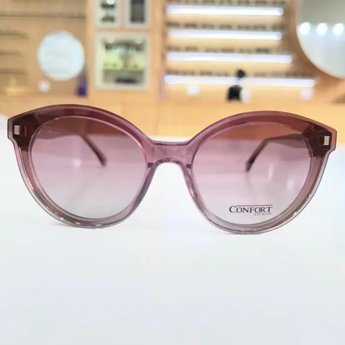 Gros plan sur lunettes œil de chat rose transparent, branches fines et décor carré aux coins supérieurs.