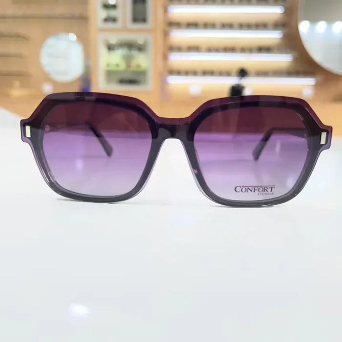 Gros plan sur des lunettes clips rectangulaires violettes avec rivet métallique sur le côté et plastique brillant.