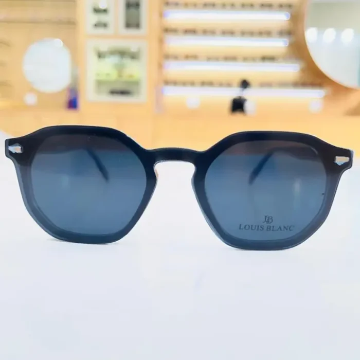 Lunettes clips homme noires portées, monture géométrique épaisse mate avec détails transparents et éléments métalliques visibles.