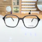 Vue de face de lunettes clips rectangulaires noir translucide, monture brillante aux branches fines et bords lisses.