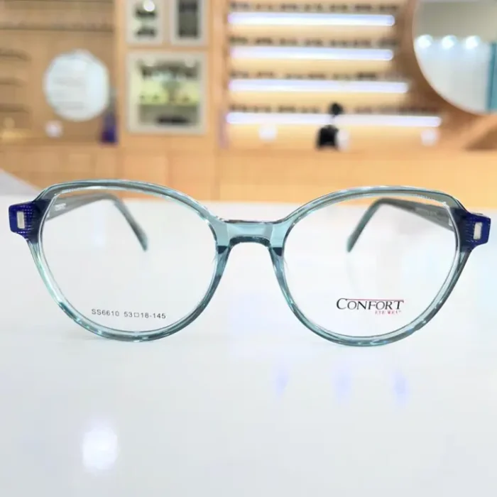 Vue de face de lunettes femme rondes bleu clair, monture plastique brillante avec branches larges et charnières visibles.