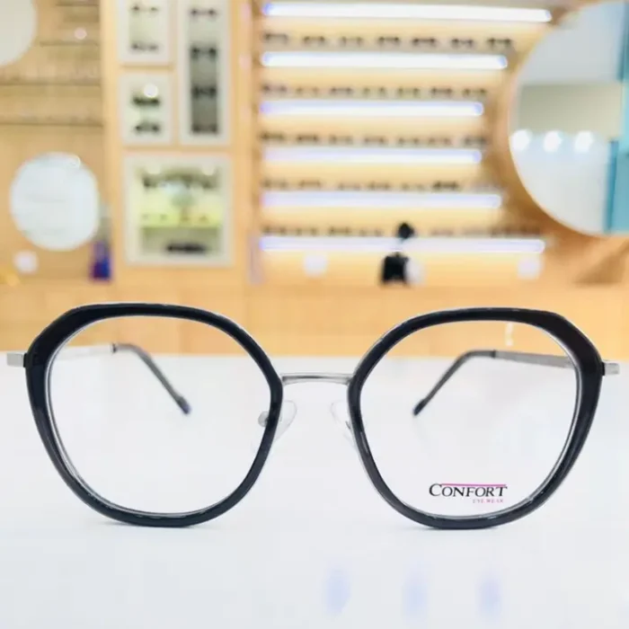 Lunettes hexagonales noires fines avec pont transparent et branches légères, style moderne et élégant.