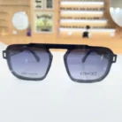 Gros plan de lunettes homme noires carrées, plastique brillant, monture épaisse et angulaire aux branches robustes.