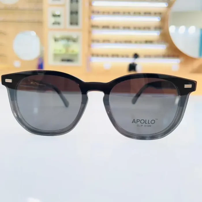 Gros plan sur lunettes homme noires rectangulaires, monture plastique brillante avec petits éléments métalliques.