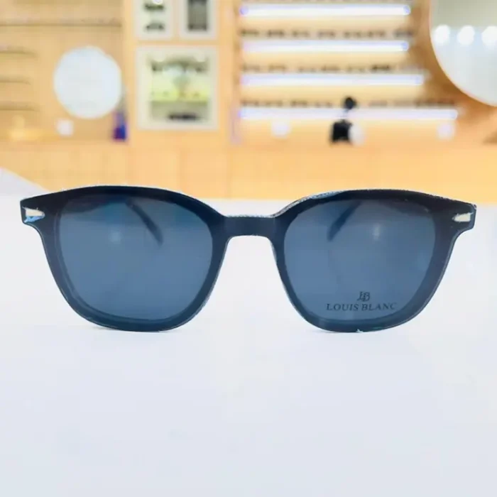 Lunettes homme noires rectangulaires portées en extérieur, monture plastique mate, design épuré pour usage quotidien.