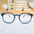 Vue de face de lunettes homme octogonales bleues en plastique brillant, branches fines, style classique élégant.