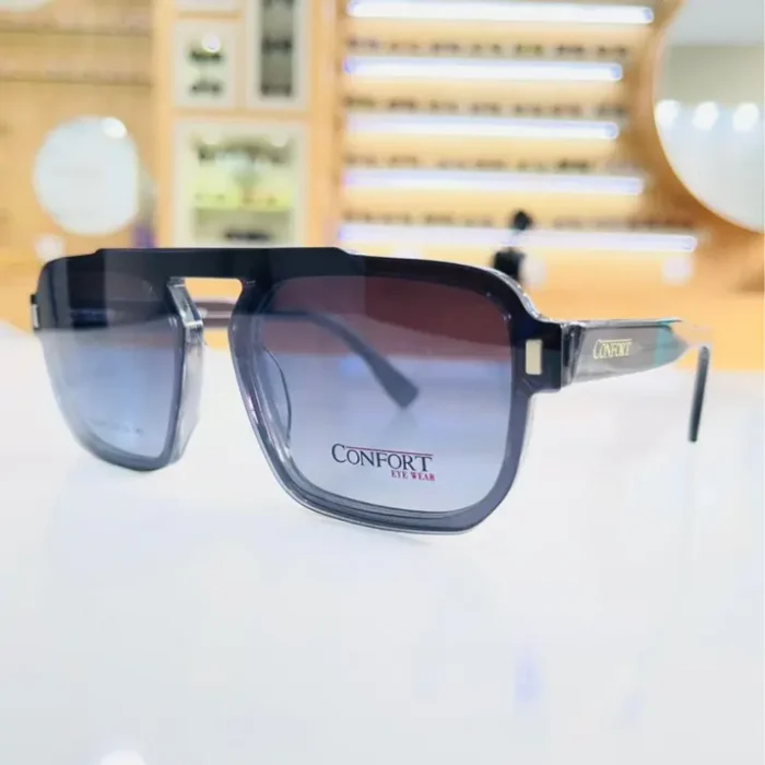 Lunettes homme rectangulaires noires avec touches transparentes et logo sur les branches, monture large brillante portée en situation.