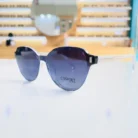 Lunettes œil de chat bleues portées, branches transparentes et éléments métalliques visibles, style mode chic pour femme.