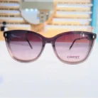 Gros plan sur lunettes œil de chat marron avec verres dégradés rose/violet et monture brillante épaisse.