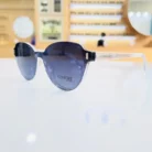 Gros plan de lunettes œil de chat noires, branches fines transparentes et décoration subtile aux charnières, finition brillante.