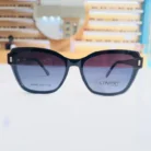 Lunettes œil de chat noires avec dégradé bleu, bord épais et détails métalliques aux coins, présentées en vue multiple.