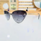 Vue de face de lunettes œil de chat noires avec branches fines dorées et embouts noirs, style chic.