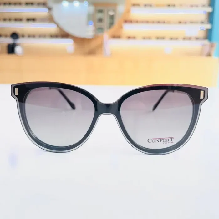 Lunettes œil de chat noires portées, finition brillante, éléments dorés visibles sur la monture et touches transparentes.