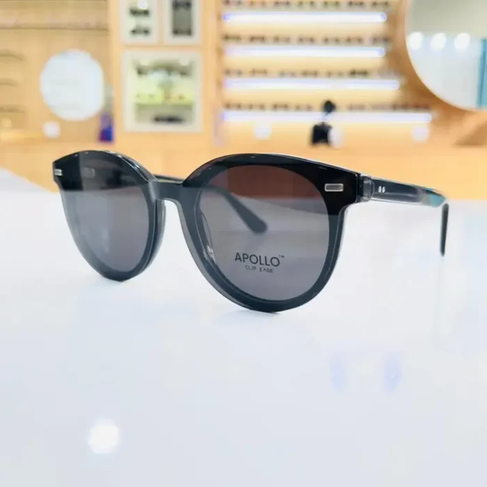 Lunettes noires style œil de chat, finition brillante, portées pour un look moderne avec décorations métalliques aux charnières.