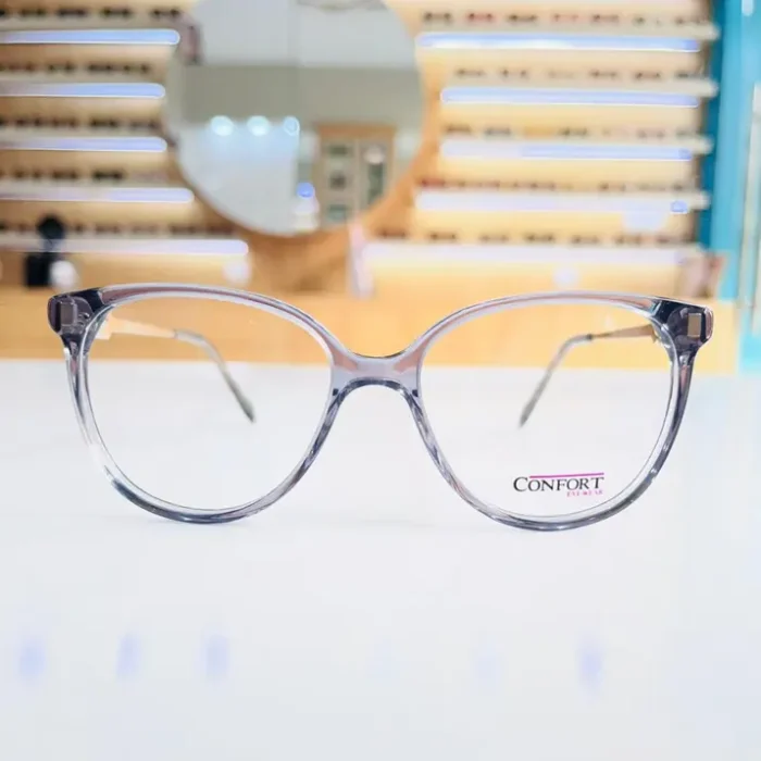 Lunettes œil de chat transparent gris portées en situation, style sobre, branches fines et finition brillante.