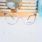 Vue de face de lunettes œil de chat transparentes en plastique, monture fine avec branches fines et logo visible.