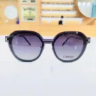 Lunettes oversize noires arrondies en plastique brillant, branches droites avec éléments métalliques visibles.