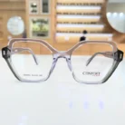 Lunettes rectangulaires transparentes à monture angulaire brillante avec branches noires légèrement épaisses, vue de face.