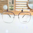 Lunettes rectangulaires transparentes avec détails violets, monture fine en métal et plaquettes nasales, vue de face.