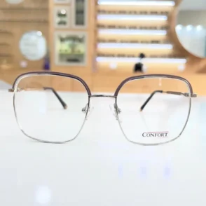 Lunettes rectangulaires transparentes avec détails violets, monture fine en métal et plaquettes nasales, vue de face.