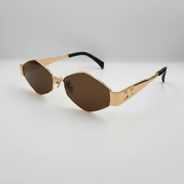 Lunette de soleil Celine femme géométrique dorée Lunette de soleil Celine femme à monture dorée brillante, forme géométrique, verres marron foncé et branches épaisses à motif.