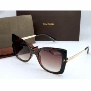 Lunette de soleil Tom Ford femme à monture écaille, branches dorées métalliques, verres avec logo Tom Ford et boîte marron.