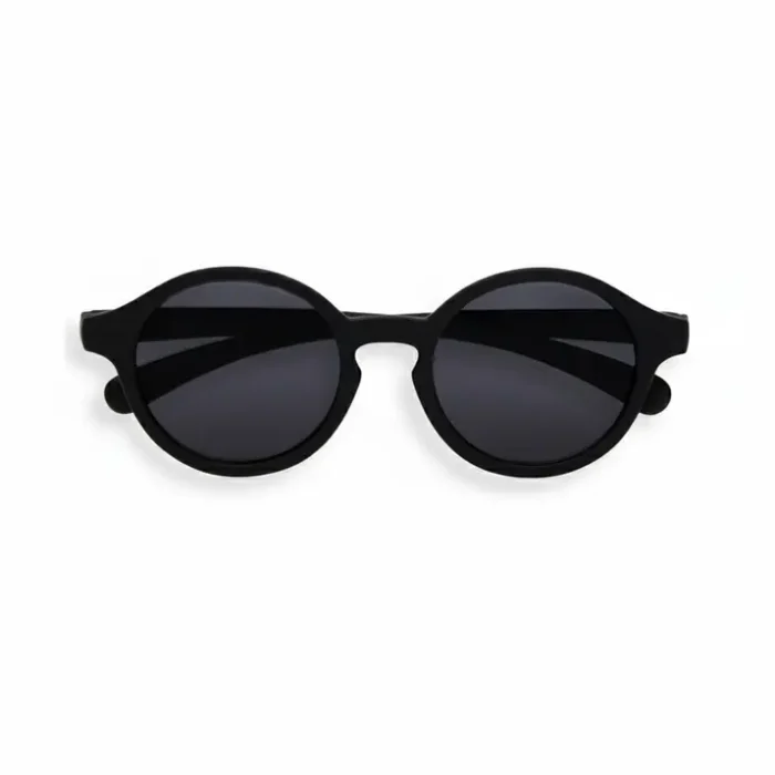 Lunette de soleil enfant ronde noire à monture épaisse, avec verres foncés, vue de face sur fond clair.