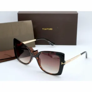 Lunette de soleil femme Tom Ford à monture épaisse écaille de tortue, verres teintés foncés et branches doré et noir.