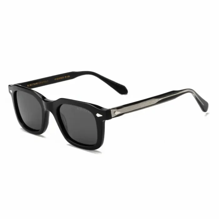 Lunette de soleil luxe noire monture épaisse Lunette de soleil luxe noire à monture épaisse rectangulaire, verres teintés noirs et branches au motif métallique subtil.