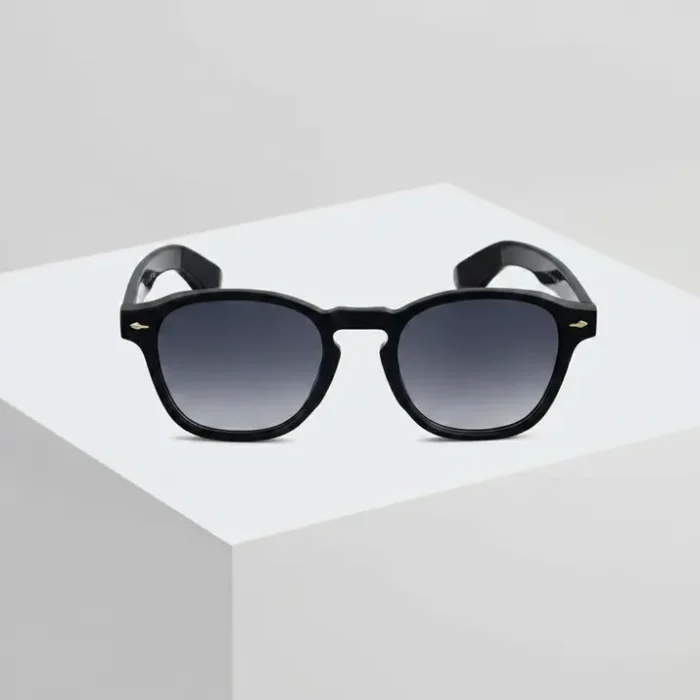 Lunette de soleil noir élégante à monture épaisse Lunette de soleil noir avec monture noire épaisse, verres teintés et détails métalliques dorés près des charnières.