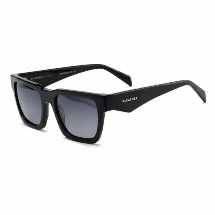 Les lunettes de soleil homme à monture rectangulaire noire, branches épaisses et verres dégradés foncés pour protection UV.