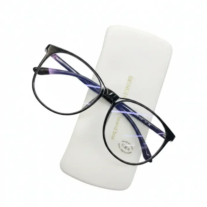 Lunette de soleil anti lumiere bleue monture noire Lunette de soleil anti lumiere bleue à monture noire arrondie, verres clairs avec reflet violet, avec étui blanc.