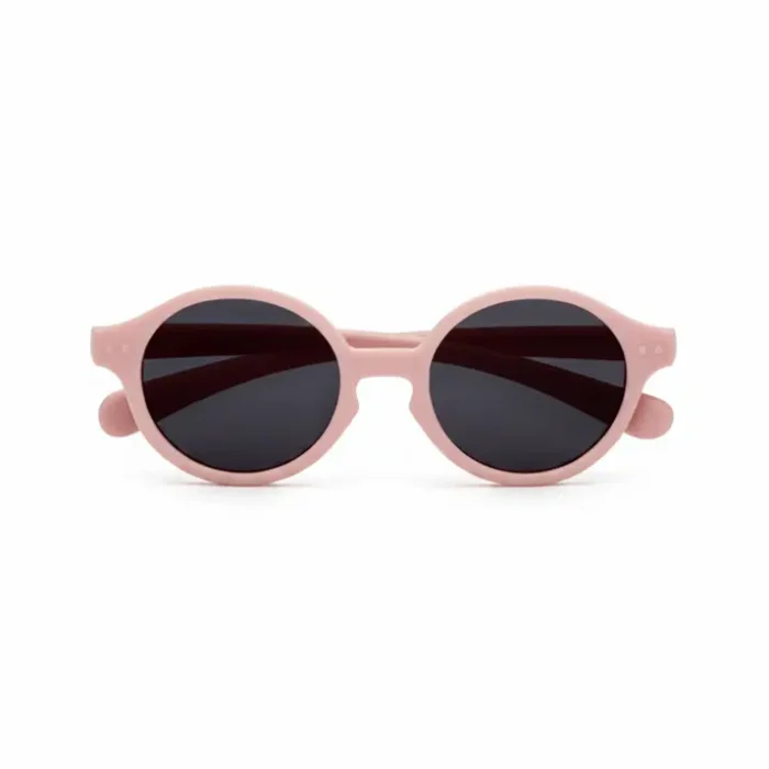 Lunette de soleil bébé rose pastel avec verres ronds teintés noir, monture compacte et branches courtes adaptées aux tout-petits.