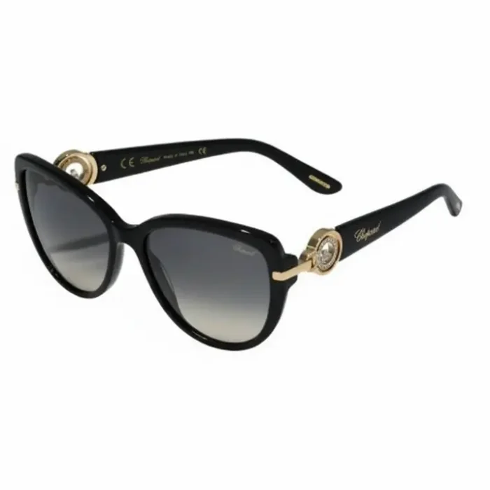 Lunette de soleil femme Chopard noire à monture épaisse, verres dégradés noir-gris et détails dorés sur les branches.