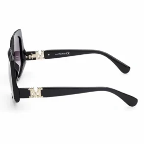 Lunette de soleil femme noir avec monture noire, verres foncés et branches épaisses ornées d’un M doré.