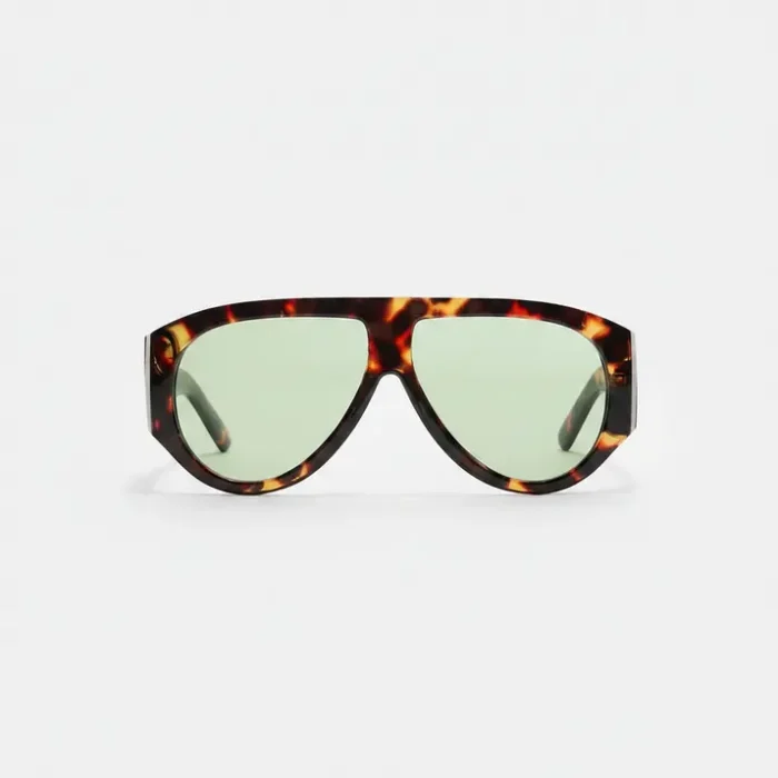 Lunette de soleil femme retro à monture épaisse écaille de tortue et verres ovales verts légèrement teintés.