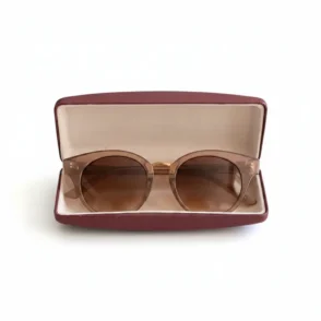 Lunette de soleil ronde rétro avec verres marron et monture transparente brunâtre, posée dans un étui ouvert.