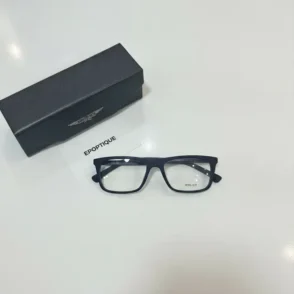 Lunette de vue Police à monture noire épaisse rectangulaire avec verres transparents, posée à côté d’un étui rigide noir.
