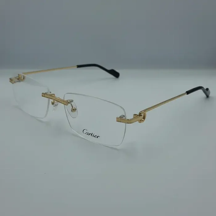 Lunettes de vue Cartier pour homme sans monture, branches dorées fines, embouts noirs, plaquettes transparentes et logo Cartier sur un verre.