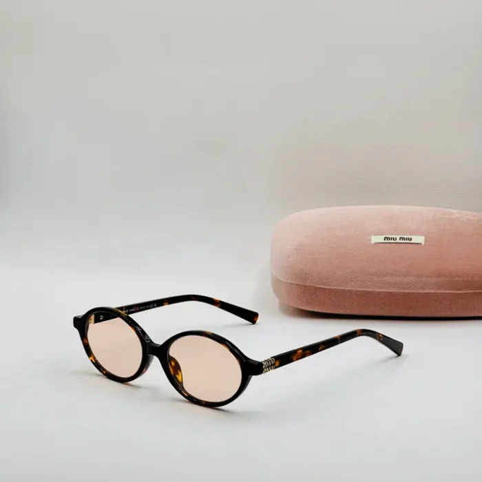 Miu Miu lunettes de vue ovales écaille de tortue Miu Miu lunettes de vue ovales à motif écaille de tortue avec verres clairs, posées près d’un étui rose Miu Miu.
