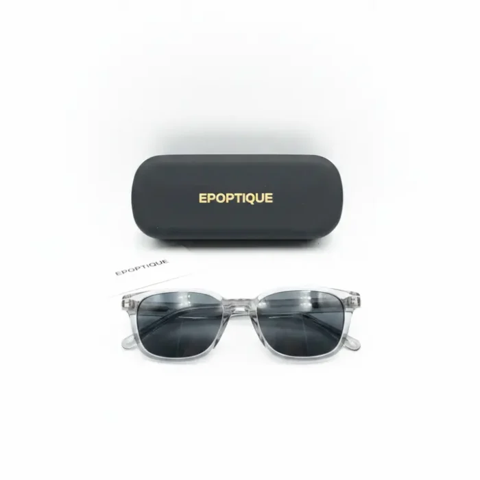 Opticien lunette de soleil rectangulaire transparente Opticien lunette de soleil à monture plastique transparente rectangulaire, verres noirs, avec étui noir et notice à côté.